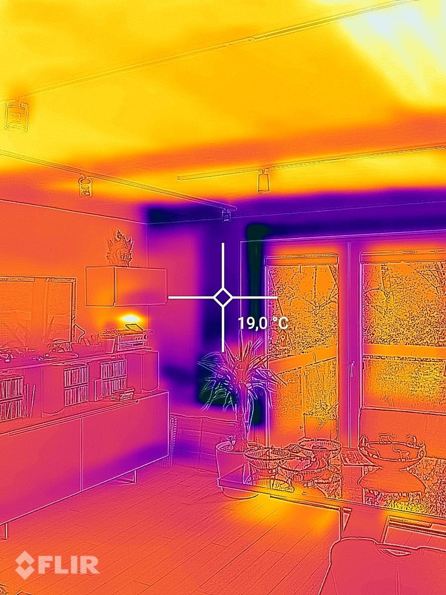 Termogramă a unui living cu tavan cald datorită încălzirii prin tavan și un punct de măsurare de 19,0 grade la peretele exterior de lângă ușa terasei.